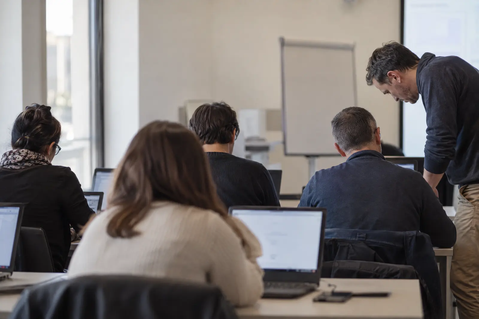 Formateur aidant un participant pendant une formation sur ordinateur