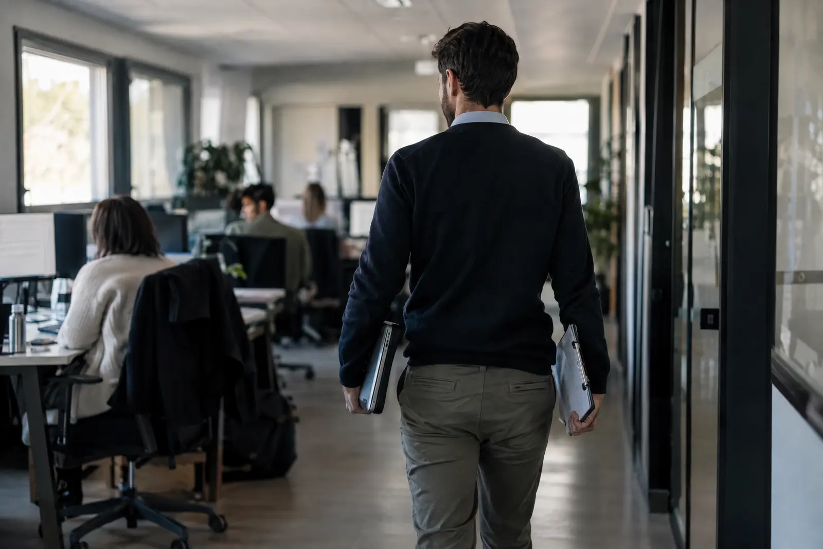 Auditeur traversant un plateau de bureaux avec un classeur