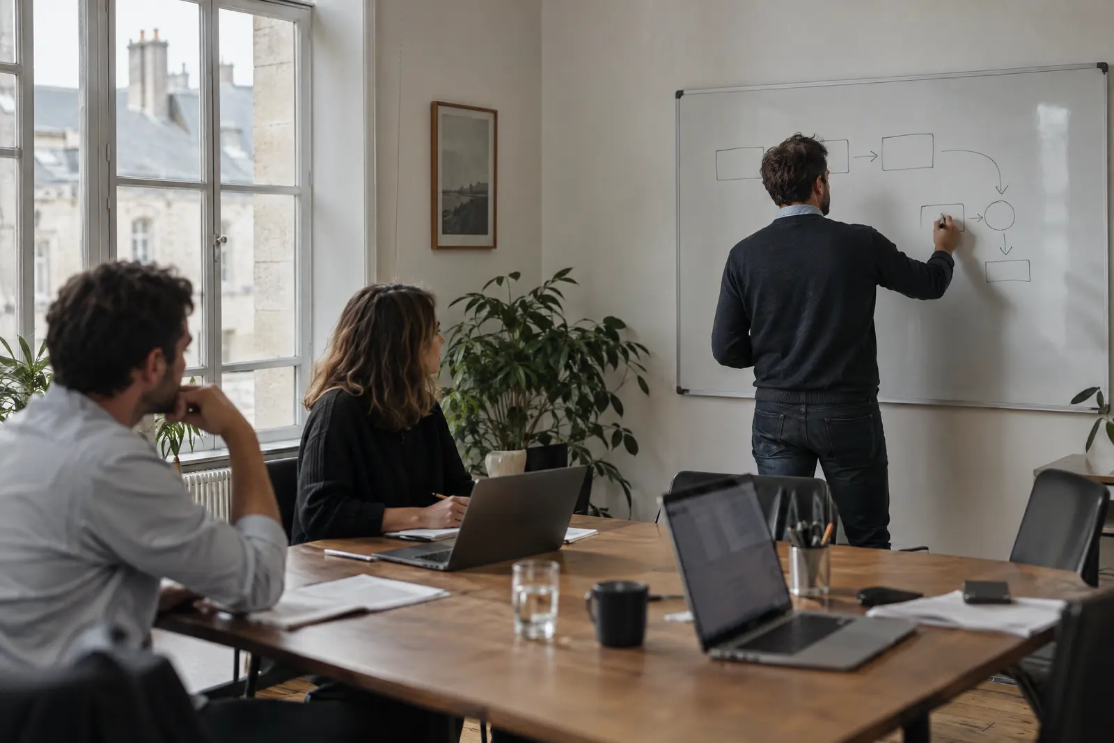 Consultant dessinant une feuille de route au tableau pendant une réunion